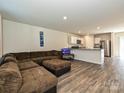 Open-concept living area with hardwood floors, a large sectional couch, and a combined kitchen space at 323 J C Dellinger Rd, Cherryville, NC 28021