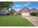 Charming brick home featuring a well-manicured lawn and a two-car garage at 4797 Chesney Nw St, Concord, NC 28027