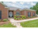 Close-up view of a home's entrance with a stone path, manicured bushes, and a white front door with wreath at 502 Roxanne Nw Ct, Concord, NC 28027