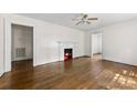 Open living space with a cozy fireplace, ceiling fan, and polished hardwood floors at 505 Franklin Ave, Shelby, NC 28150