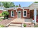 Traditional brick home featuring a tiled porch, manicured landscaping, and a security system at 536 Carroll St, Statesville, NC 28625