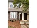 A view of the front doors of a two story tan townhouse with a rock facade on one side at 571 Goldstaff Ln, Charlotte, NC 28273