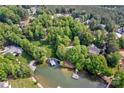 Stunning aerial view of a lake community with mature trees, lawns, and private boat docks at 669 Kenway Loop, Mooresville, NC 28117