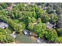 Picturesque aerial view of homes and a lakefront property featuring lush trees and a private dock at 669 Kenway Loop, Mooresville, NC 28117