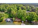 Gorgeous aerial view of lake property with dense trees, stone steps, a dock and clear water at 669 Kenway Loop, Mooresville, NC 28117