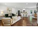 Open-concept living space with hardwood floors, stylish decor, and seamless flow to kitchen and dining area at 6938 Wrentree Dr, Charlotte, NC 28210