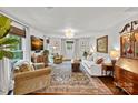 Sun-drenched living room with a cozy fireplace, dark wood floors and large windows at 6946 Woodstock Dr, Charlotte, NC 28210