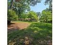 Spacious front yard with mature trees surrounding a beautiful home at 695 Knollcrest Ne Dr, Concord, NC 28025