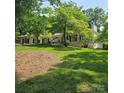 Lovely brick home surrounded by mature trees and a well-manicured lawn at 695 Knollcrest Ne Dr, Concord, NC 28025