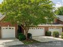 Brick townhome exterior featuring a two-car garage and mature landscaping at 705 Congressional Ln, Fort Mill, SC 29708