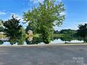 Community pond reflecting the blue sky and neighborhood homes, framed by mature trees, is picturesque at 705 Congressional Ln, Fort Mill, SC 29708
