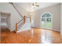 Spacious living room featuring hardwood floors, large windows and a grand staircase at 7114 Kinsmore Ln, Charlotte, NC 28269