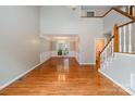 An elegant living room featuring hardwood floors, a staircase and an open view of the adjacent dining area at 7114 Kinsmore Ln, Charlotte, NC 28269