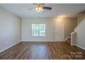 Bright living room with hardwood floors, a ceiling fan, and a staircase leading to the upper level at 8226 Gabon Ct, Charlotte, NC 28215