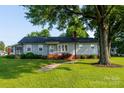 Charming home with a well-kept lawn, mature trees, and a welcoming front porch along a walkway at 100 S Rudisill Ave, Cherryville, NC 28021