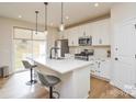 Modern kitchen with white cabinetry, an island with pendant lighting, and stainless steel appliances at 1028 Grays Mill Rd, Charlotte, NC 28215