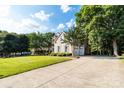 Spacious driveway leading to a well-maintained home with an attached garage, surrounded by mature trees at 10927 Thornhill Club Dr, Charlotte, NC 28277
