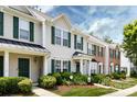 Attractive townhouses showcasing varied facades, green shutters, and manicured landscaping along a sidewalk at 12328 Jessica Pl, Charlotte, NC 28269