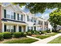 Well-maintained townhouse with green shutters, manicured landscaping, and a charming covered entrance in a neighborhood setting at 12328 Jessica Pl, Charlotte, NC 28269