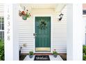 Inviting front entryway with a green door, decorative wreath, and a 'Welcome' mat adding a cozy touch at 12328 Jessica Pl, Charlotte, NC 28269