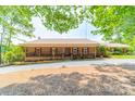 Traditional brick home featuring a welcoming front porch, perfect for enjoying the peaceful surroundings at 12705 Caldwell Rd, Charlotte, NC 28213