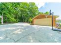 Attached brick garage with a basketball hoop and a wide paved driveway at 12705 Caldwell Rd, Charlotte, NC 28213