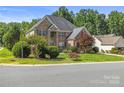 Beautiful two-story brick home with lush landscaping and a side-entry garage, offering a suburban charm at 128 Sugar Thyme Ln, Mooresville, NC 28115