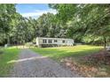 Home featuring a gravel driveway, lush lawn, and mature trees for privacy and a tranquil setting at 1310 Glasscock Rd, Rock Hill, SC 29730
