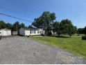 Single-story home featuring a gravel driveway, a spacious front yard, and a storage shed at 13211 Asbury Chapel Rd, Huntersville, NC 28078