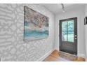 Stylish entryway with patterned wallpaper, hardwood floors, and decorative art at 1619 Flynnwood Dr, Charlotte, NC 28205