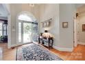 Inviting foyer featuring a decorative glass door, hardwood floors, and stylish console table at 16527 Woolwine Rd, Charlotte, NC 28278