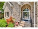 Elegant brick home entrance with a decorative glass door, arched entryway, and landscaped surroundings at 16527 Woolwine Rd, Charlotte, NC 28278