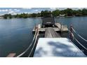 Wooden boat dock featuring a covered boat lift on calm water surrounded by lush greenery at 17719 Springwinds Dr, Cornelius, NC 28031