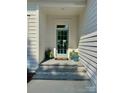 Stylish home featuring a light blue front door with stone steps and curated potted plants at 17719 Springwinds Dr, Cornelius, NC 28031