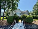 Stunning white home as seen from dock, surrounded by lush landscaping at 17719 Springwinds Dr, Cornelius, NC 28031