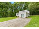 Back elevation featuring a sleek design and lush landscaping, complemented by a long driveway at 221 Reliance Rd, Kings Mountain, NC 28086