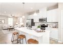Open kitchen with stainless appliances, white cabinets, an island with seating, and views of the living room at 2342 Nadine Ln, Charlotte, NC 28216
