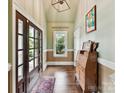 Welcoming foyer with hardwood floors, paneled walls, and natural light at 2526 Sherwood Ave, Charlotte, NC 28207