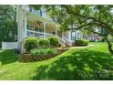 Landscaped front yard featuring a raised garden bed and a covered front porch with white railings at 2908 Barnard Castle Ln, Matthews, NC 28104