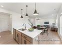 Bright, open-concept kitchen features a center island, stainless steel appliances, and modern pendant lighting at 32612-B Millingport Rd # 7157, New London, NC 28127
