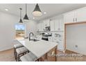 Modern kitchen with a center island, white cabinets, stainless steel appliances, and bright natural light at 32612-B Millingport Rd # 7157, New London, NC 28127