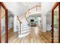 Bright foyer featuring a curved staircase with white spindles, hardwood floors, and an open view to the living room at 3324 Greenhurst Dr, Matthews, NC 28104