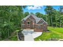 Stunning brick facade with a well-manicured lawn and curved driveway leading to a grand entrance at 3324 Greenhurst Dr, Weddington, NC 28104