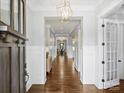 Elegant hallway with hardwood floors, wainscoting, and a view into the dining area at 431 Wonderwood Dr, Charlotte, NC 28211