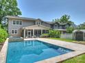 The backyard features a beautiful pool with travertine decking and a large screened in porch on the home at 431 Wonderwood Dr, Charlotte, NC 28211