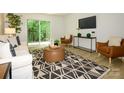 Bright living room featuring modern furniture, a TV, and sliding glass doors to an outdoor patio at 4754 Hedgemore Dr # E, Charlotte, NC 28209