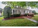Inviting home with a covered front porch and a meticulously maintained lawn and landscaping at 506 Academy St, McAdenville, NC 28101