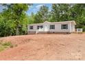 This house offers a charming curb appeal with its gray siding, black shutters, and welcoming front porch at 5090 Beaver Dam Way, Bessemer City, NC 28016