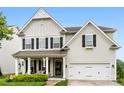 Charming two-story home featuring black shutters, a covered porch, and an attached two-car garage at 537 Lakeview Dr, McAdenville, NC 28101