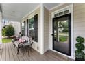 Inviting front porch with seating area and decorative 'hello' wreath on the front door at 537 Lakeview Dr, McAdenville, NC 28101